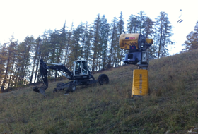 Travaux sur les pistes de ski avec une pelle araignée