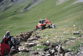 Travaux sur les pistes de ski avec une pelle araignée. Protection contre les avalanches